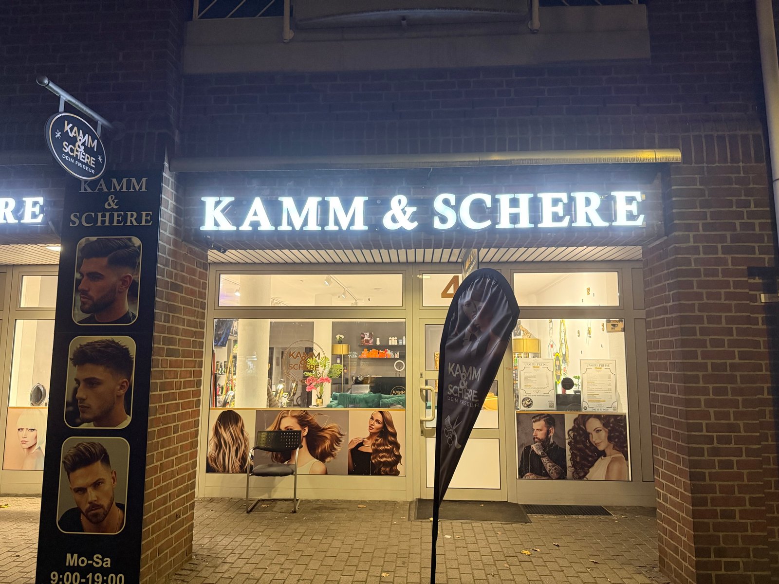 Beleuchtete Ladenfront von Kamm & Schere in Norderstedt